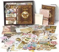 A large assortment of vintage-style decorative stickers, embellishments, and craft supplies arranged on a white background, with a few items standing upright in the back.
