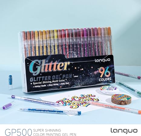 Languo GP500 Glitter Gel Pen set with 96 colors in a clear plastic case, displayed with several loose pens and sample painted stickers on a light blue background.